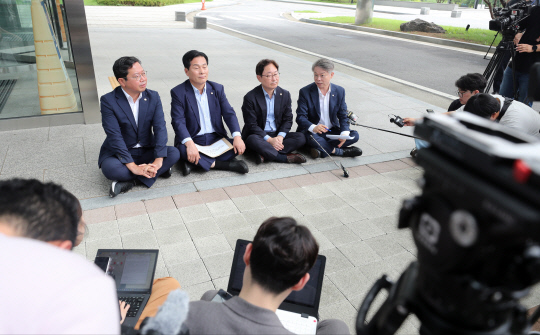 지난 7월24일 더불어민주당 법률위원장인 김승원(왼쪽부터) 의원, 인권위원장인 주철현 의원, 정치탄압대책위원장인 박범계 의원, 인권위 상임고문인 민형배 의원이 쌍방울 그룹 대북송금 사건에 연루돼 구속기소된 이화영 전 경기도 평화부지사에 대한 검찰 수사에 항의하기 위해 수원지방검찰청을 찾았다가 지검장과의 면담 요구가 거절당하자 청사 앞에 앉아 농성하고 있다.<연합뉴스 사진>